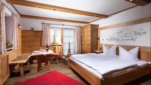 Ein Schlafzimmer aus Holz mit Bett, Schreibtisch und einem roten Teppich.