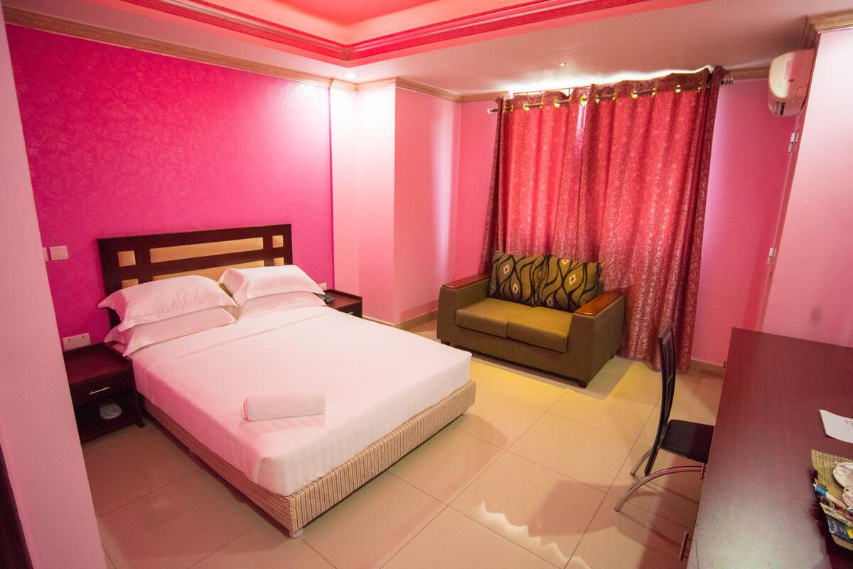 Une chambre d’hôtel avec un grand lit, un canapé et un bureau.