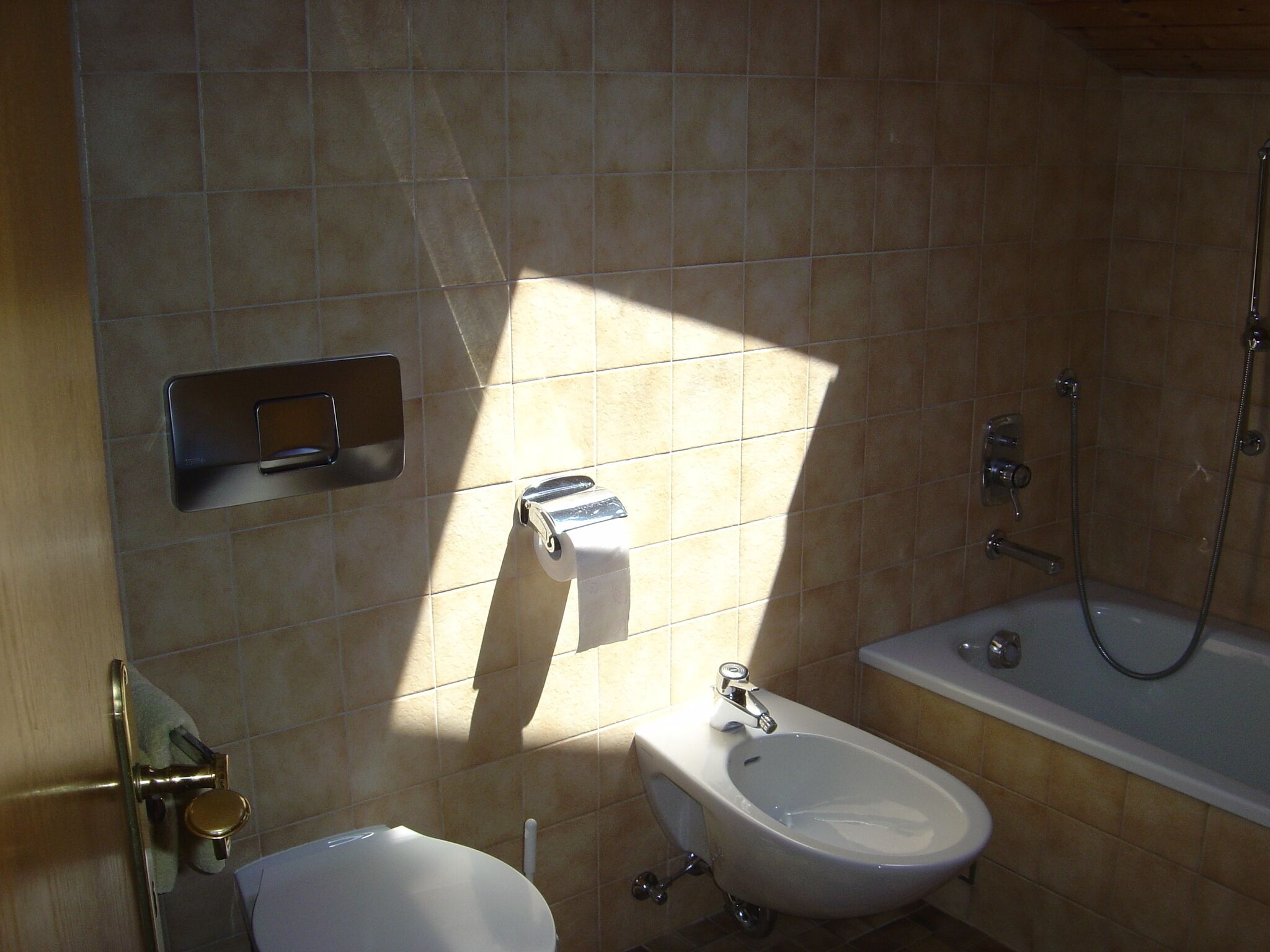 A bathroom with a toilet, bidet, and bathtub.