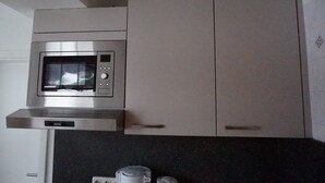 Une cuisine équipée d’un four à micro-ondes encastré et d’une cuisinière.