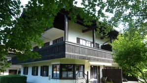 Un bâtiment à deux étages doté d’un balcon, d’un porche couvert et d’une pelouse bien entretenue.