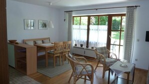 Une pièce spacieuse comprenant un coin repas, un canapé et une table avec des chaises.