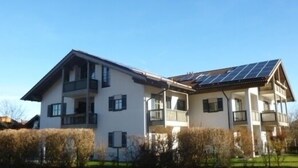 En tvåvåningsbyggnad med ett platt tak och solpaneler.