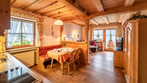 Interior acogedor de una cabaña de madera con comedor, cocina y sala de estar.