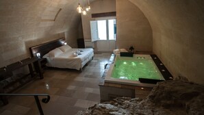 Un dormitorio con cama, banco, bañera y ventana.