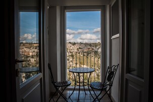 A balcony with a view of rocky terrain and a clear sky.