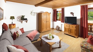 Ein Wohnzimmer mit einer Couch, einem Couchtisch, einem Fernseher und einem Schrank.
