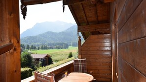 A wooden cabin with a balcony overlooking a mountainous landscape. - 5. Fewo Hochgern, 37 qm, 1- 3 Pers., 1 Schlafzimmer, 1 Wohnschlafraum, Süd-Balkon (Grassau)
