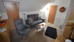 Un espacio habitable pequeño con sofá, sillón y una mesita de centro.