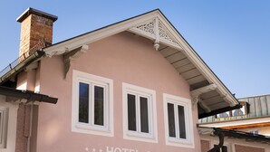 A pink building with the sign "HOTEL GARNI Bergfried & Schönblick".