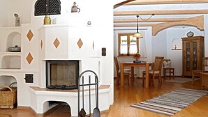 A cozy living room with a fireplace, wooden furniture, and a dining area. - holiday flat (Truchtlaching)
