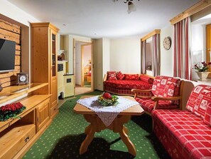 Relax in this traditional room with a flat-screen TV, comfortable sofas, and a small table for dining.