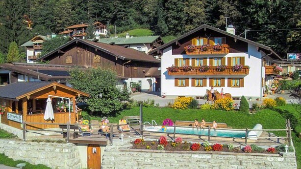 A traditional chalet with a swimming pool, surrounded by lush gardens and a stone wall. - Ferienwohnung 1 für 2 bis 4 Personen, 75 qm, 2 Schlafzimmer, Balkon (Schönau am Königssee)
