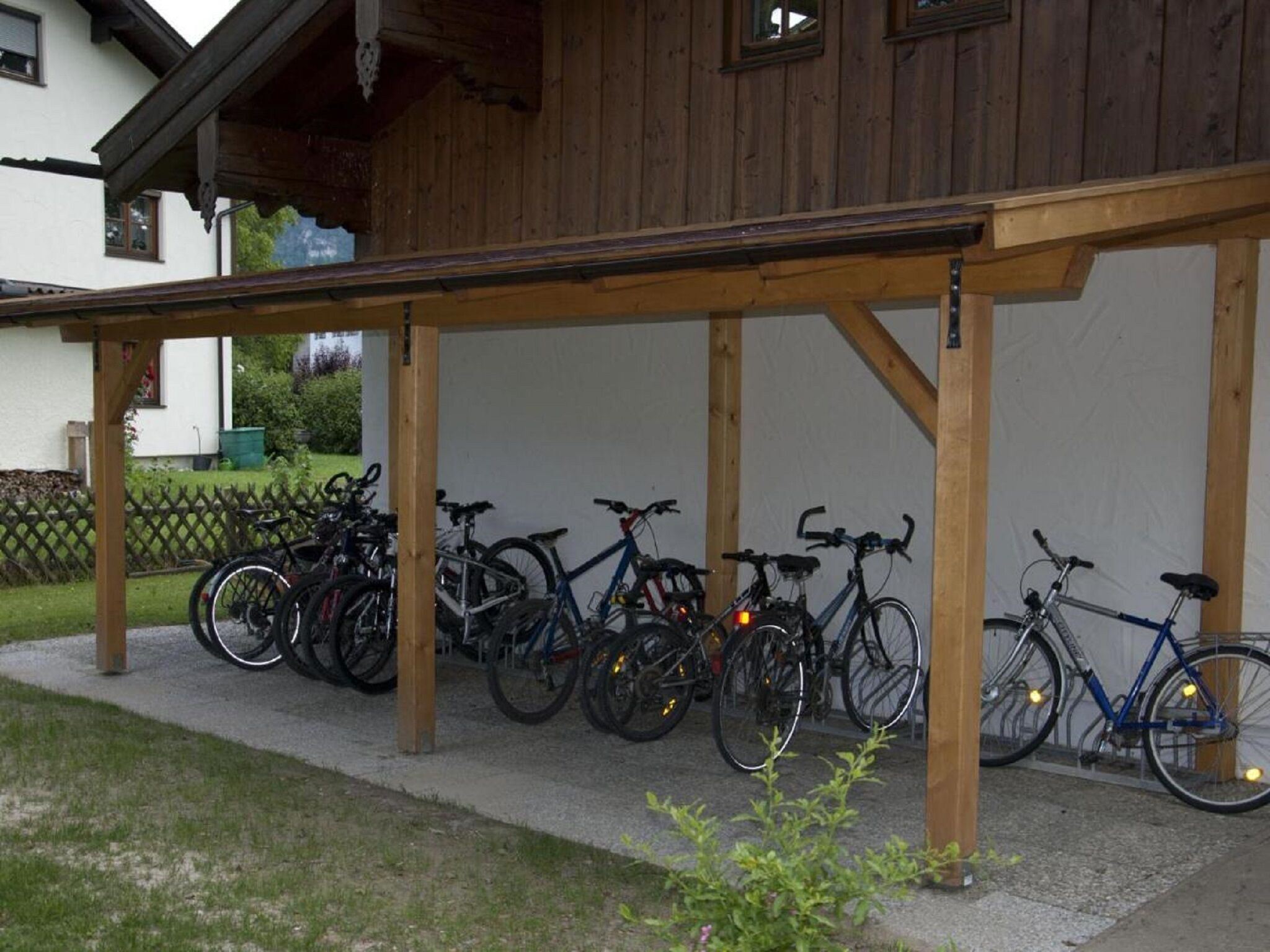 A covered bike parking area with multiple bicycles.