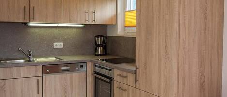 Een koelkast, een oven, een kookplaat, een vaatwasser