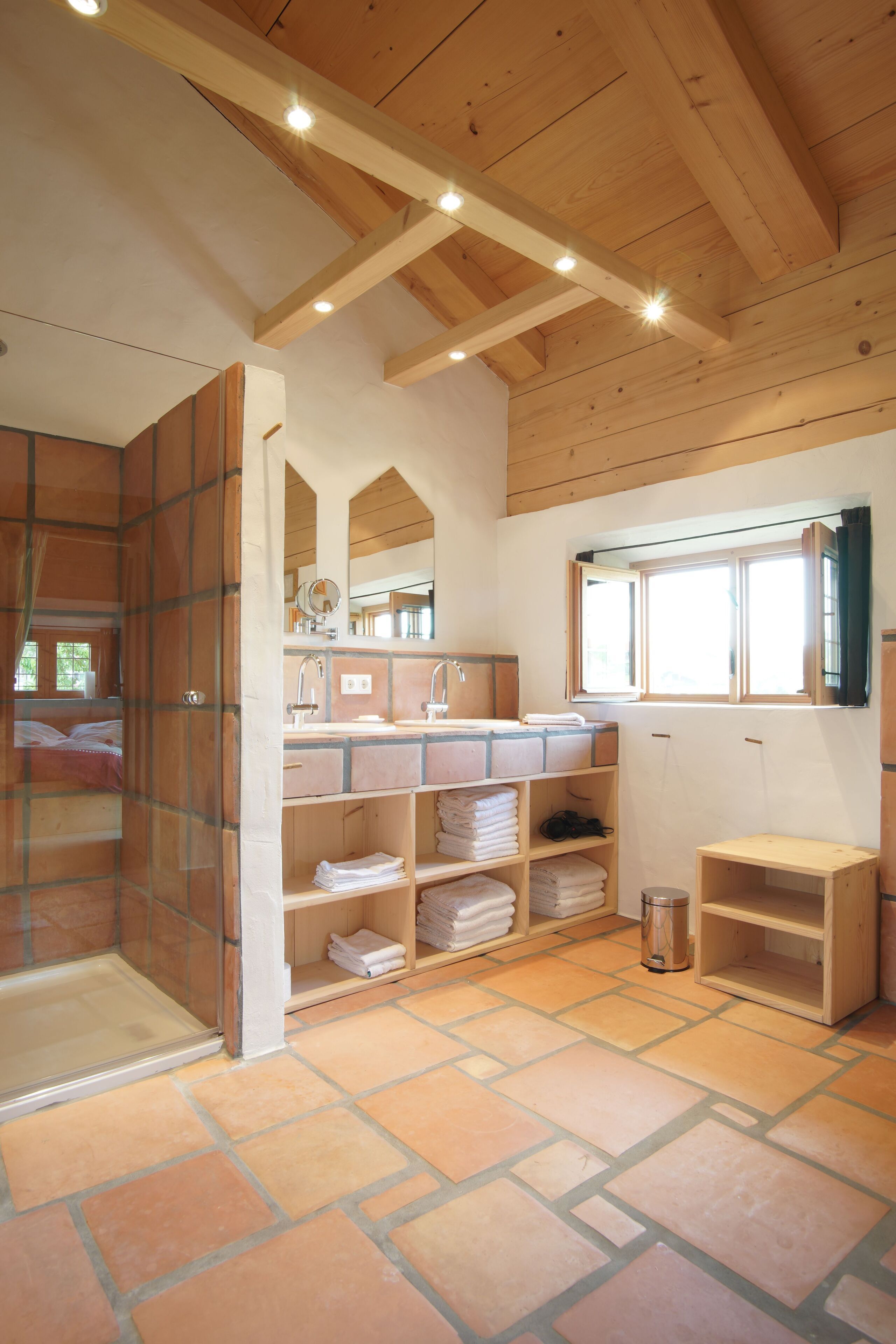 Une salle de bain avec une douche, un lavabo, un miroir et une fenêtre.