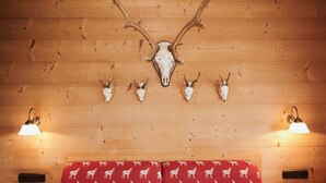 A wooden wall with mounted animal skulls and two wall-mounted lamps. - Two-room apartment 5, approx. 40sqm with spacious balcony and mountain view (Reit im Winkl)