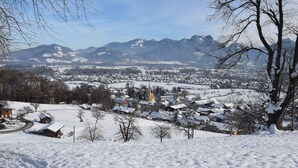 A snow-covered town with a prominent church and mountains in the background.