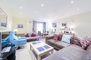 อพาร์ทเมนท์สำหรับครอบครัว, เตียงใหญ่ 1 เตียง, ห้องครัว, วิวเมือง | ห้องนั่งเล่น | ทีวีจอแบน