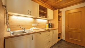 Una cocina con gabinetes de madera, un fregadero y una cafetera.