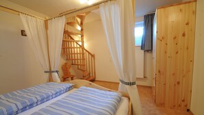 Camera da letto con due letti, una scala in legno e un'armadio in legno.