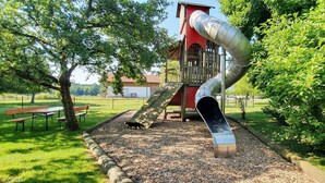 Un'area giochi con uno scivolo, una struttura per arrampicata e un'area picnic.