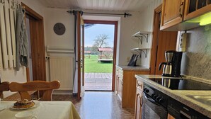 Une cuisine équipée d’une cuisinière, d’une machine à café et d’un coin repas avec une table et des chaises.