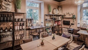 Ein gemütliches Interieur mit Holzboden, Regalen mit Flaschen, Korbmöbeln und einem Fernseher.