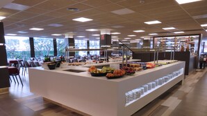 A buffet area with various food items and a seating area with tables and chairs. - Hotel Papi (Malgrat de Mar)