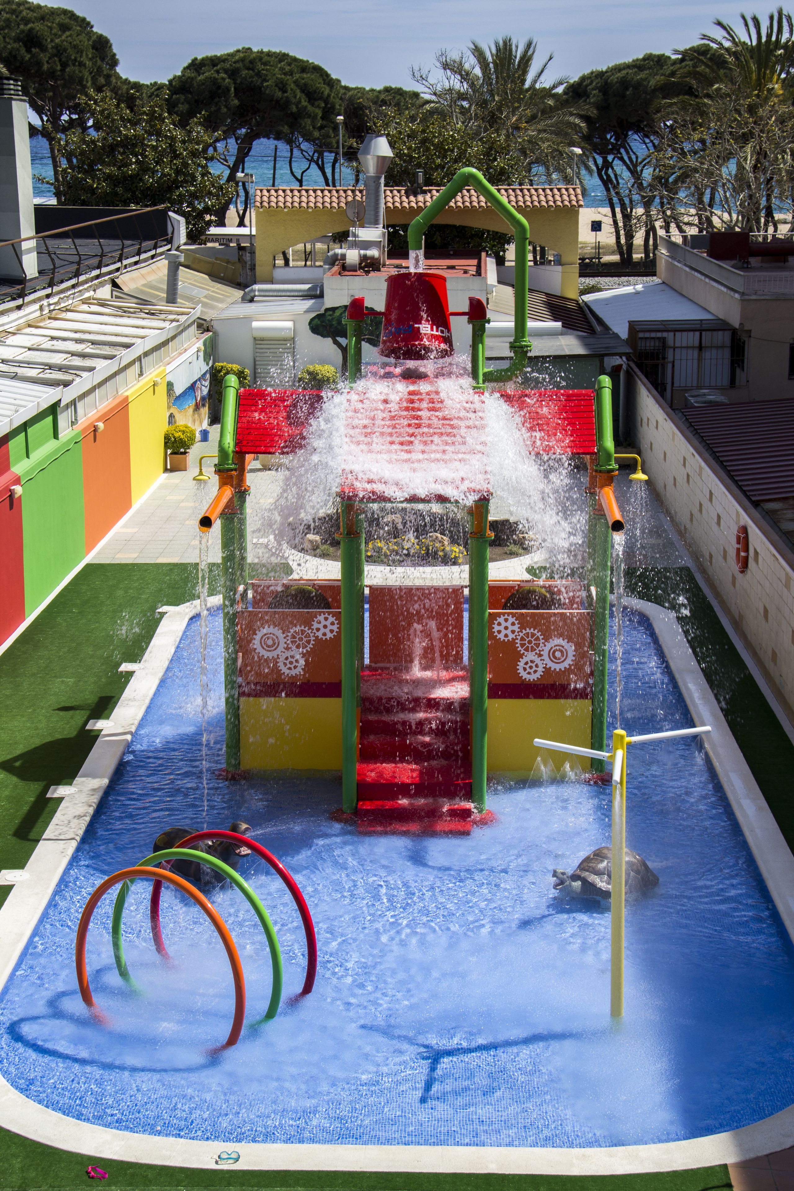 A water play area with a slide and rings.