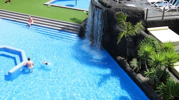 Relax by the pool surrounded by lush tropical plants and enjoy a refreshing swim in the clear water.