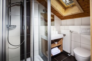 A modern bathroom with a glass-enclosed shower, a white sink, and a wooden ceiling. - Watzmann, 1-4 Pers., ca. 70 qm, 2 Schlafzimmer, 2x Dusche/WC, Bauernstube, Küche, Balkon (Bischofswiesen)