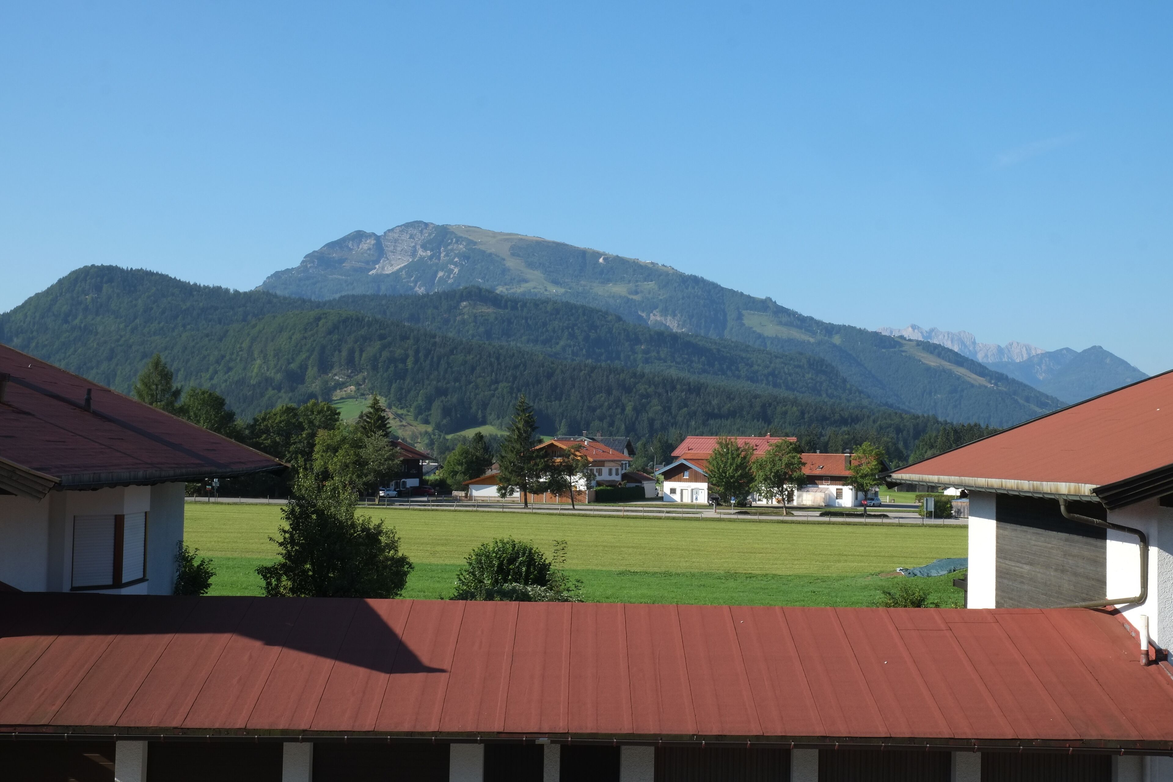 Un pueblo rural con casas y una montaña al fondo.