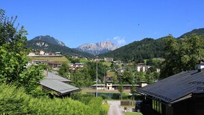 A mountainous landscape with a clear sky. There are buildings with flat roofs and some greenery in the foreground. - Ferienwohnung 3 (Berchtesgaden)