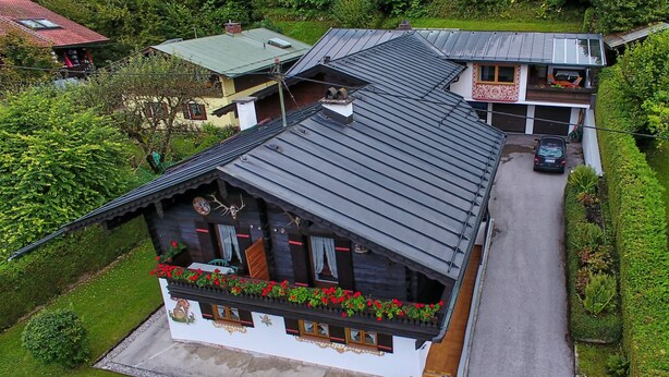 A traditional chalet with a sloped roof, a balcony with flower boxes, and a well-maintained garden. - Ferienwohnung 3 (Berchtesgaden)