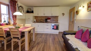 Un espace de vie compact comprenant un coin repas, une kitchenette et un canapé.