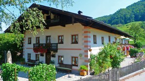 A traditional chalet with a balcony, a stone staircase, and a wooden fence. - Ferienwohnung I 45 qm°, zwei Schlafzimmer, Südbalkon und ebenerdigem Eingang° (Aschau im Chiemgau)