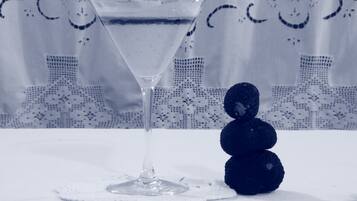 Una copa de martini con un líquido transparente sobre un mantel blanco.
