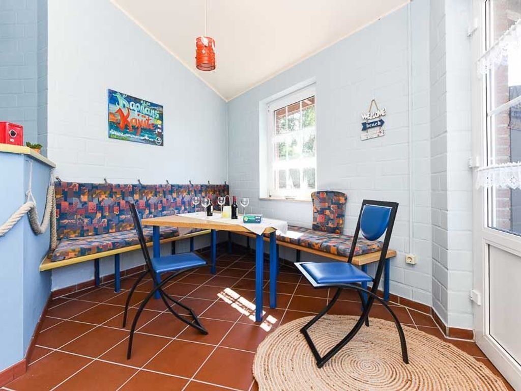 Un comedor con una mesa larga, sillas azules y un banco estampado.