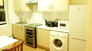 Departamento, 2 habitaciones | Cocina privada | Cafetera y tetera, refrigerador, microondas y horno 