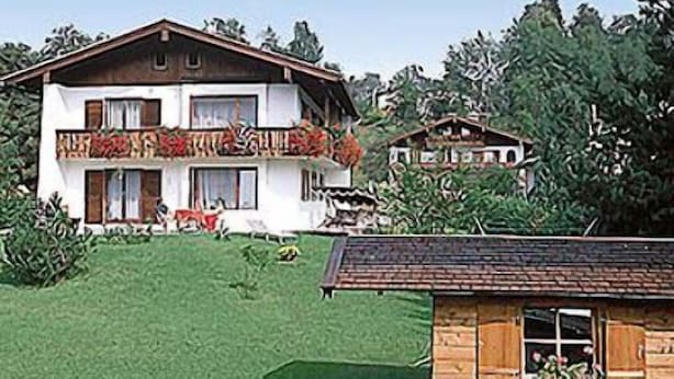 A two-story house with a balcony, a small shed, and a well-maintained lawn. - Ferienwohnung Grünstein, 1 bis 2 Personen, 54 qm, 1 Schlafzimmer, extra Küche, Balkon (Schönau am Königssee)