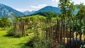 A garden with a wooden fence, various plants, and flowers. - Apartment Alm Stüberl, 65 square meters, balcony, 2 sep. Bedroom, max. 4 pers. (Ruhpolding)