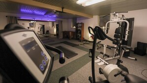 A gym with exercise equipment, a treadmill, and a weight bench.