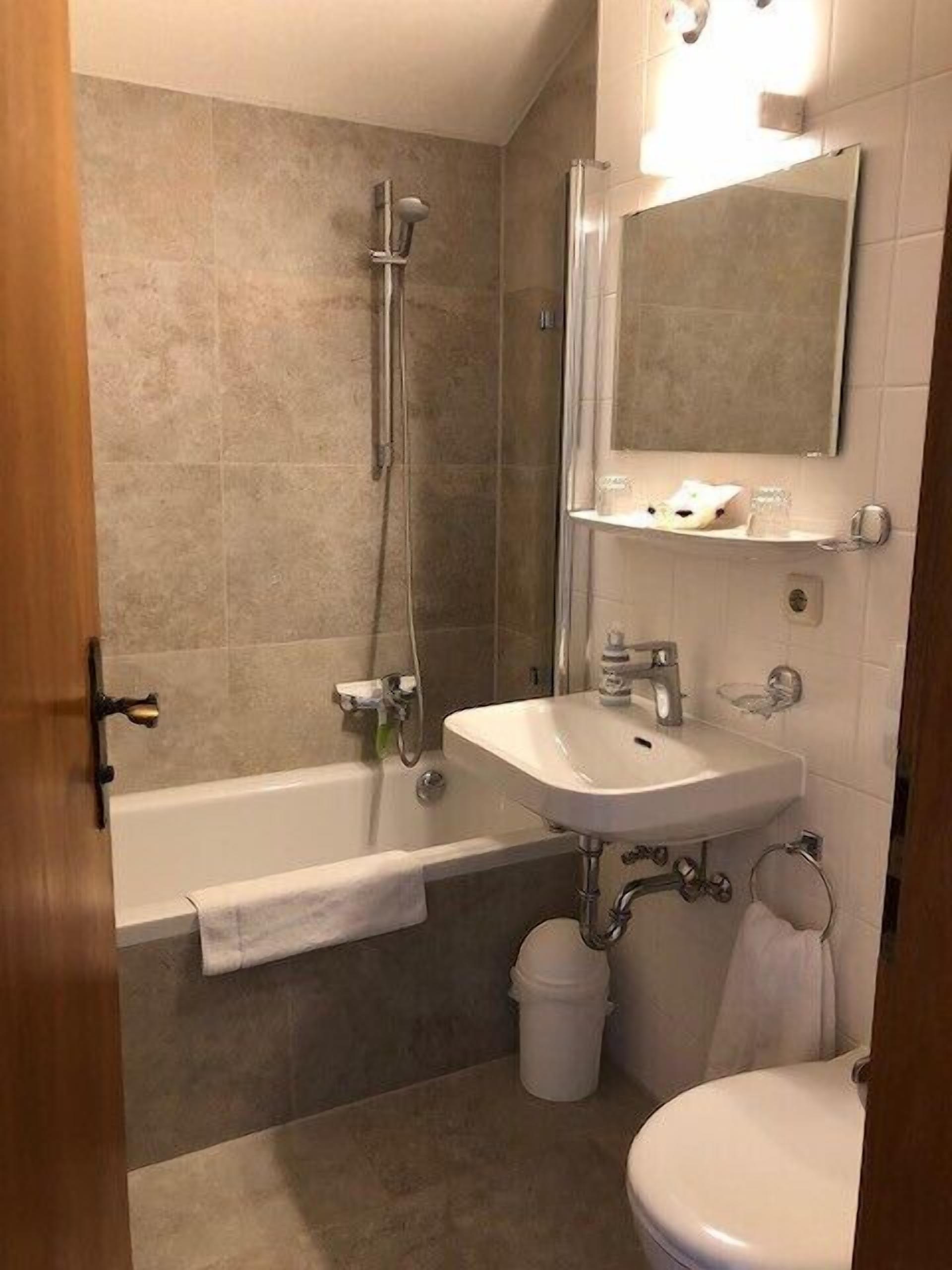 Een badkamer met een bad, wastafel en toilet.