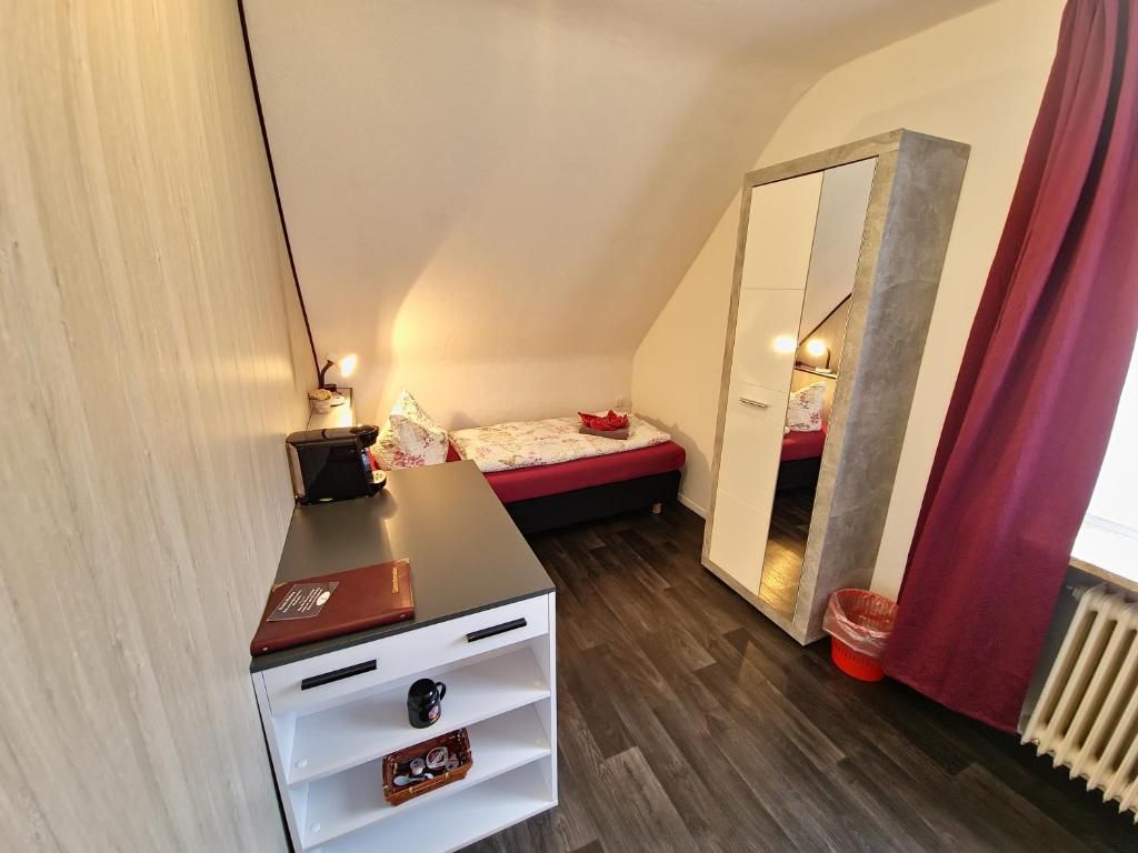Un dormitorio pequeño y acogedor con una cama, un escritorio con lámpara y un armario.