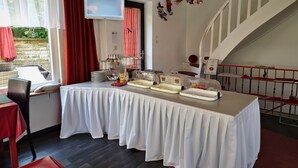 Un comedor con mesas de buffet, un televisor y una escalera.