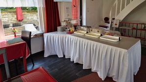 Una disposición para el desayuno con una mesa de buffet, un mapa en la pared y una escalera.