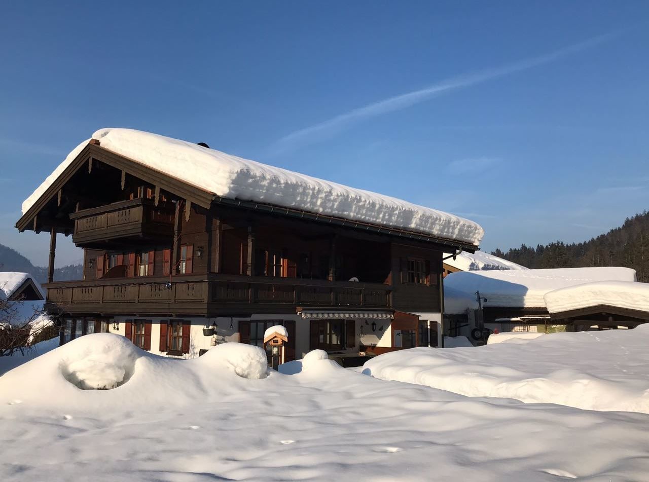 Eine Holzhütte mit schneebedecktem Dach, umgeben von Schnee.