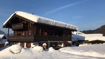 Eine Holzhütte mit schneebedecktem Dach, umgeben von Schnee.