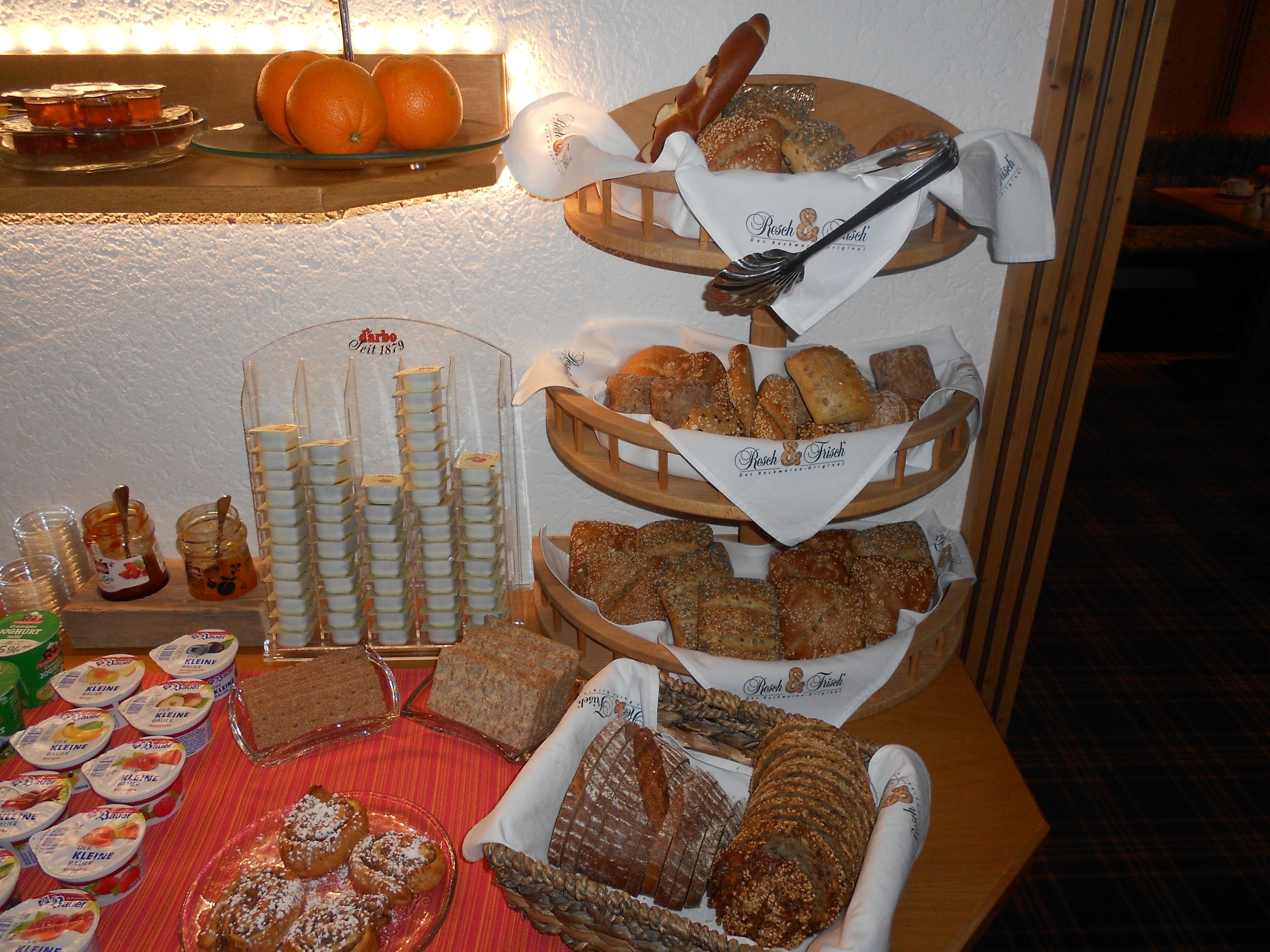 A buffet table with various food items including bread, pastries, and dairy products.